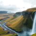 Majestic Icelandic waterfall cascading into a vibrant green valley.