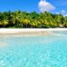Tropical island beach with clear blue water.