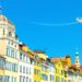 European cityscape with vibrant colors and stylized airplane.