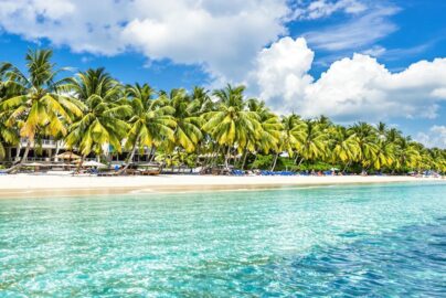 Tropical beach resort with turquoise water and palm trees.