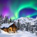 Snow-covered mountains with a cozy cabin and aurora borealis.