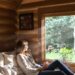 Couple relaxing in a cozy cabin with a scenic view.