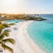 Dreamy beach with palm trees and resort.