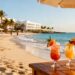 Sunny beach resort with people and tropical drinks