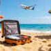 People relaxing on a sunny beach with suitcase nearby.