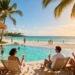 Tropical beach resort with people relaxing and swimming.