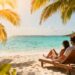 Couple relaxing on a tropical beach with clear blue water.