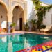 Moroccan riad courtyard with pool and lounge chairs.