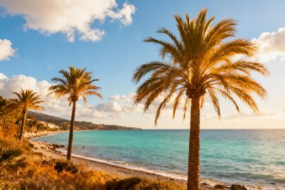 Sunny European coast with blue skies and calm water.