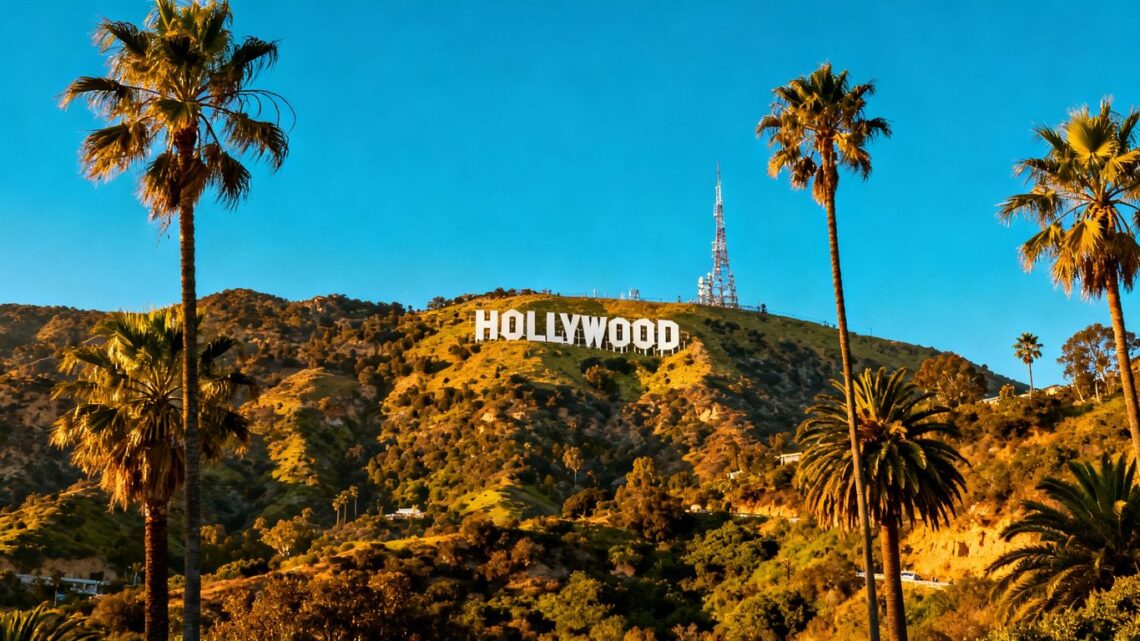 Hollywood sign with palm trees and sunny sky.