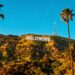 Hollywood sign with palm trees and sunny sky.