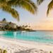 Tropical beach with resort and clear blue water.