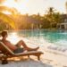Couple relaxing on a tropical beach with resort.