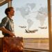 Traveler at airport with suitcase watching planes depart